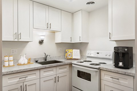 a kitchen with white cabinets and white appliances